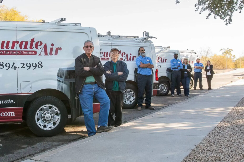 Accurate Air team members standing in front of service vans, showcasing their commitment to HVAC services and customer trust.