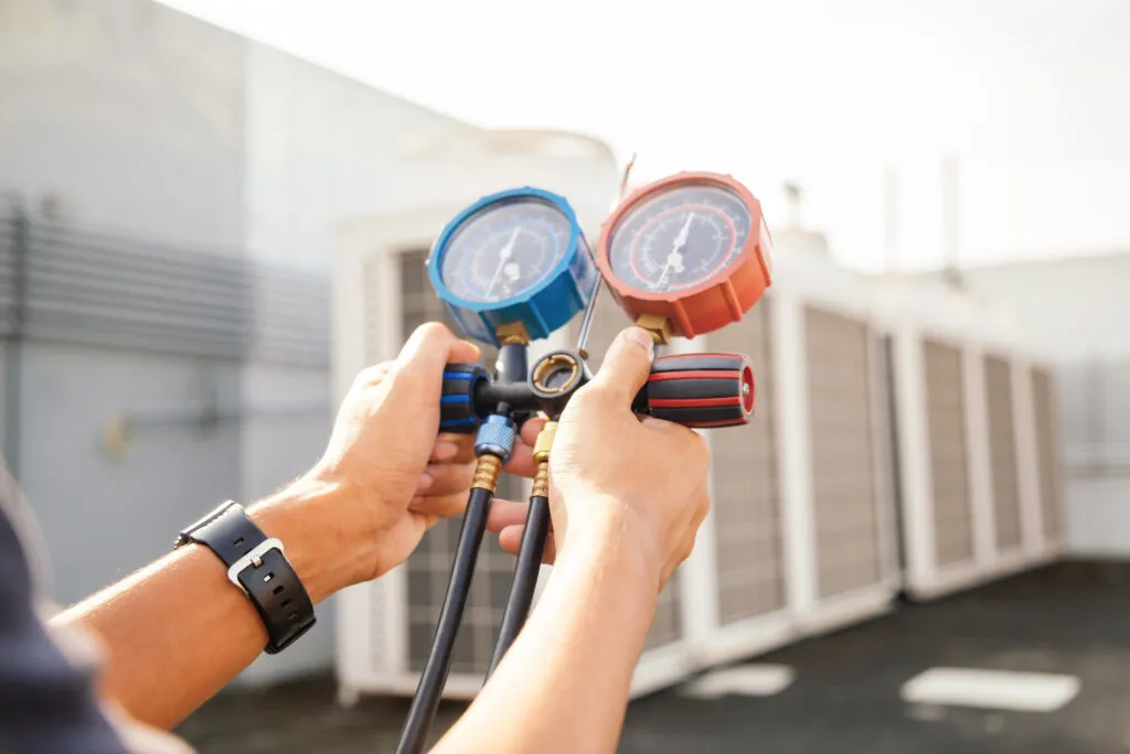 Energy-saving tips: Technician checks AC unit pressure for efficient operation. HVAC service ensures peak performance | Accurate Air