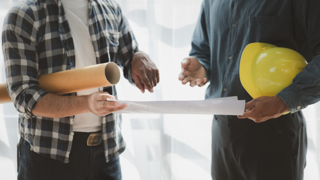 Why Hire a Licensed Contractor? Two contractors review plans, one holding a hard hat. Important to hire a licensed contractor | Accurate Air.