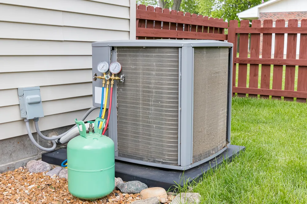 Outdoor air conditioning unit with refrigerant gauges and green refrigerant tank, emphasizing HVAC maintenance and refrigerant understanding.