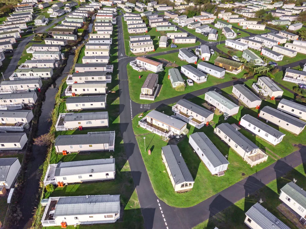 Aerial view of a mobile home park showcasing rows of mobile homes and green spaces, emphasizing the need for effective HVAC solutions in mobile living environments.