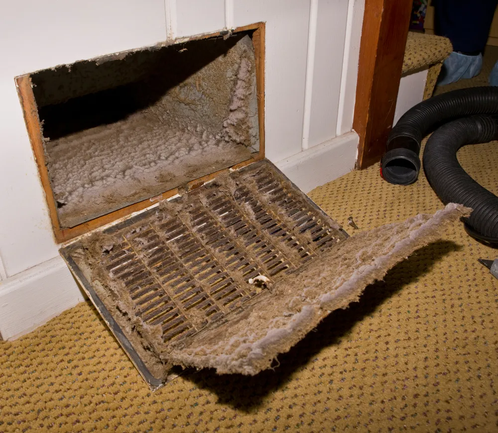 HVAC duct with a dusty, dirty vent cover, indicating the need for cleaning to improve air quality and airflow in residential systems.