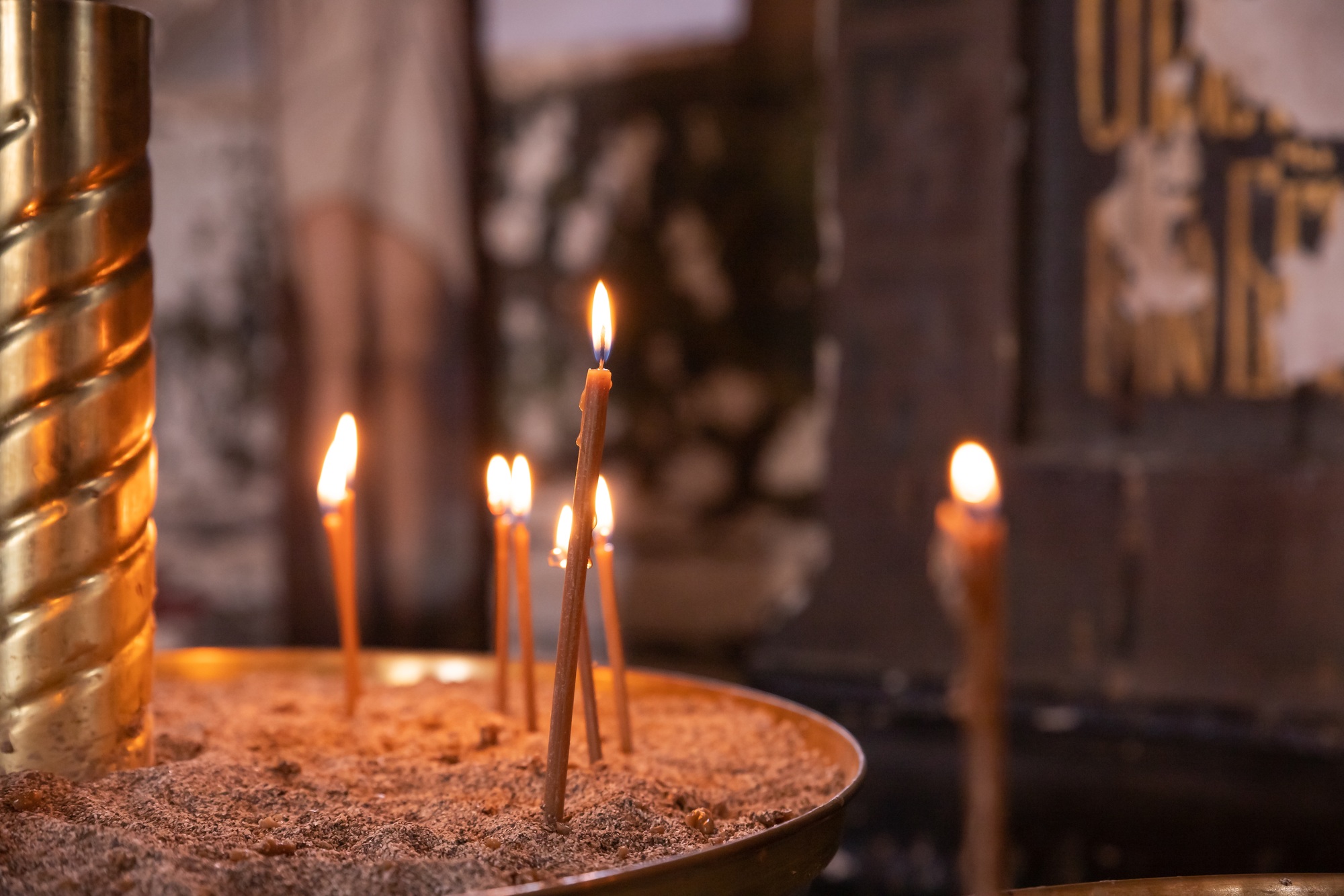 Burning candles in sand, creating a warm ambiance and soft glow, symbolizing remembrance and spirituality | Accurate Air