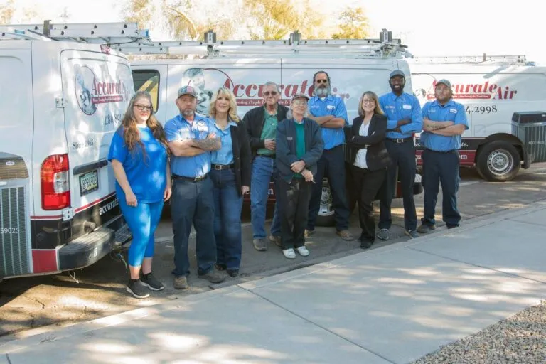 The Accurate Air team in branded polo shirts in front of two lettered service vans.