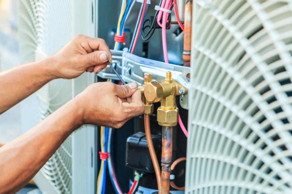 Technician repairing air conditioning unit, adjusting valves and connections, emphasizing Accurate Air's expert AC repair services in Tempe, AZ.