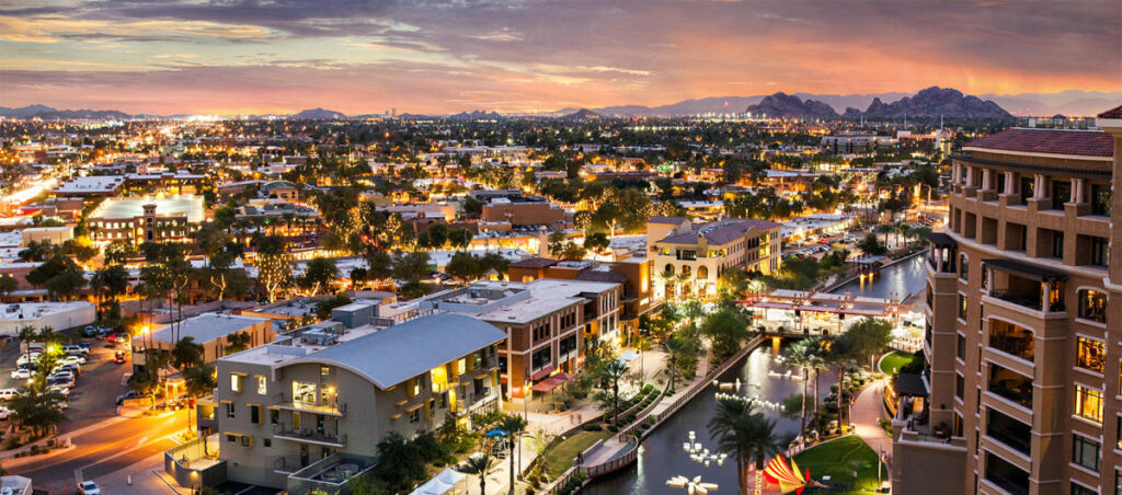 Scottsdale, AZ, cityscape at dusk. Buildings, trees, and lights illuminate the scene. HVAC Services in Scottsdale, AZ | Accurate Air
