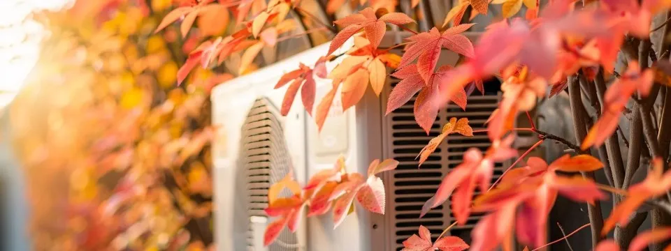 Air conditioning unit surrounded by autumn leaves, symbolizing HVAC maintenance and seasonal preparation in Tempe.