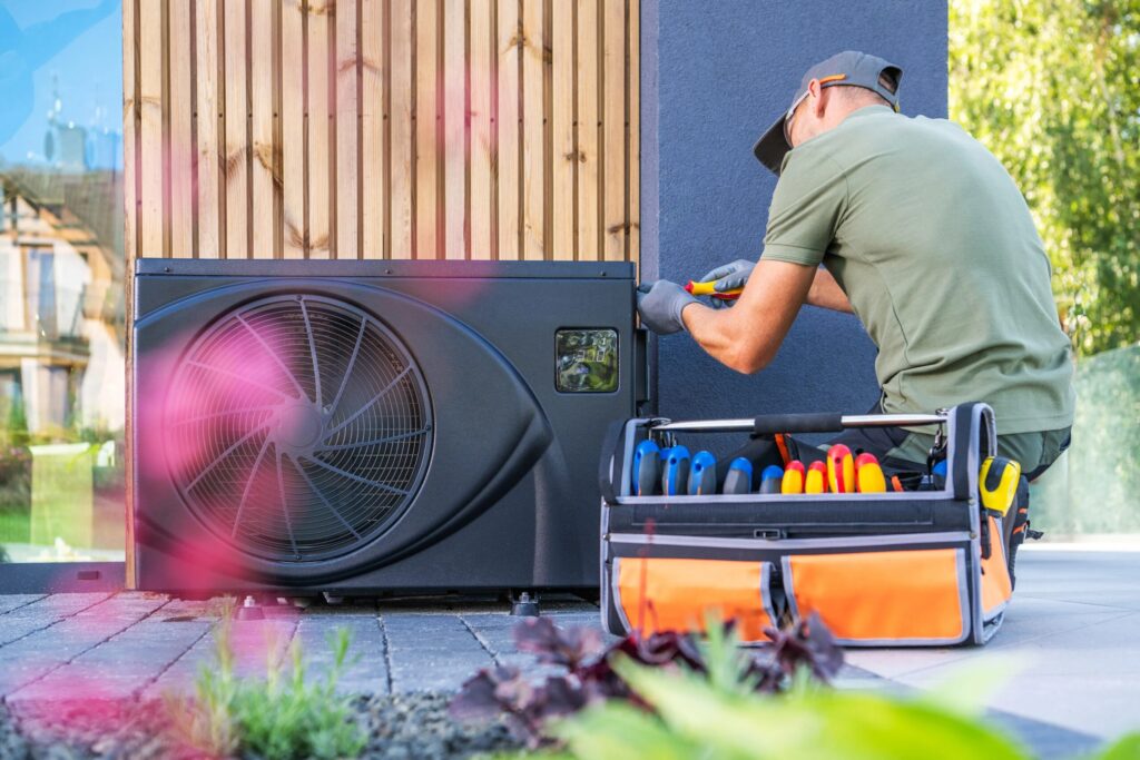 Heat Pump Installation in Tempe, AZ: Technician installing a new heat pump system outdoors with tools | Accurate Air