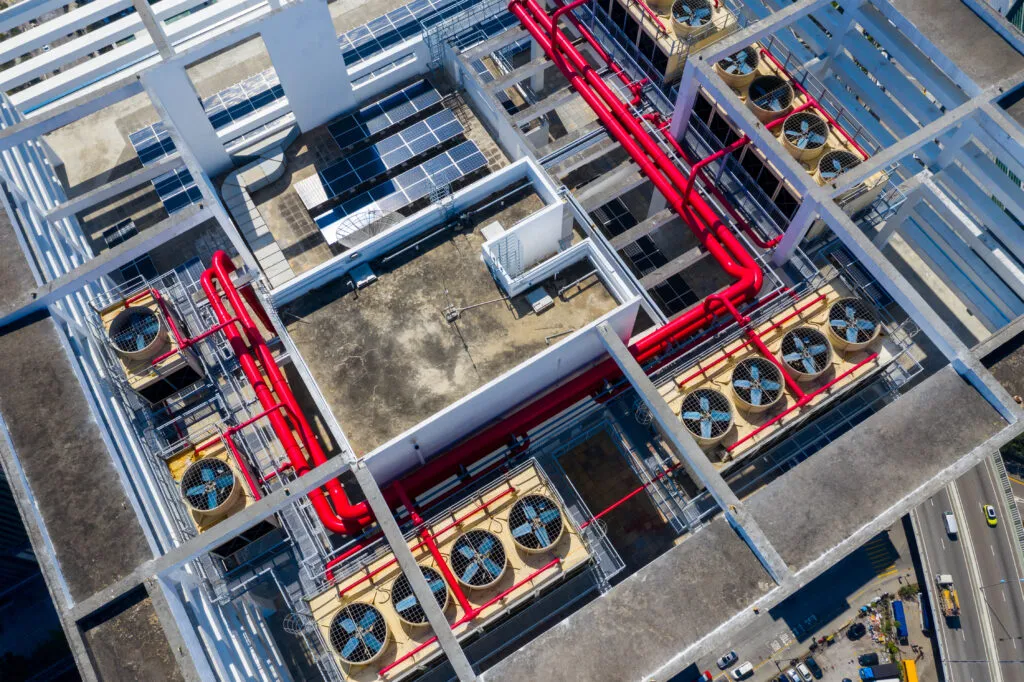 An overhead view of commercial rooftop air conditioning units and pipework.